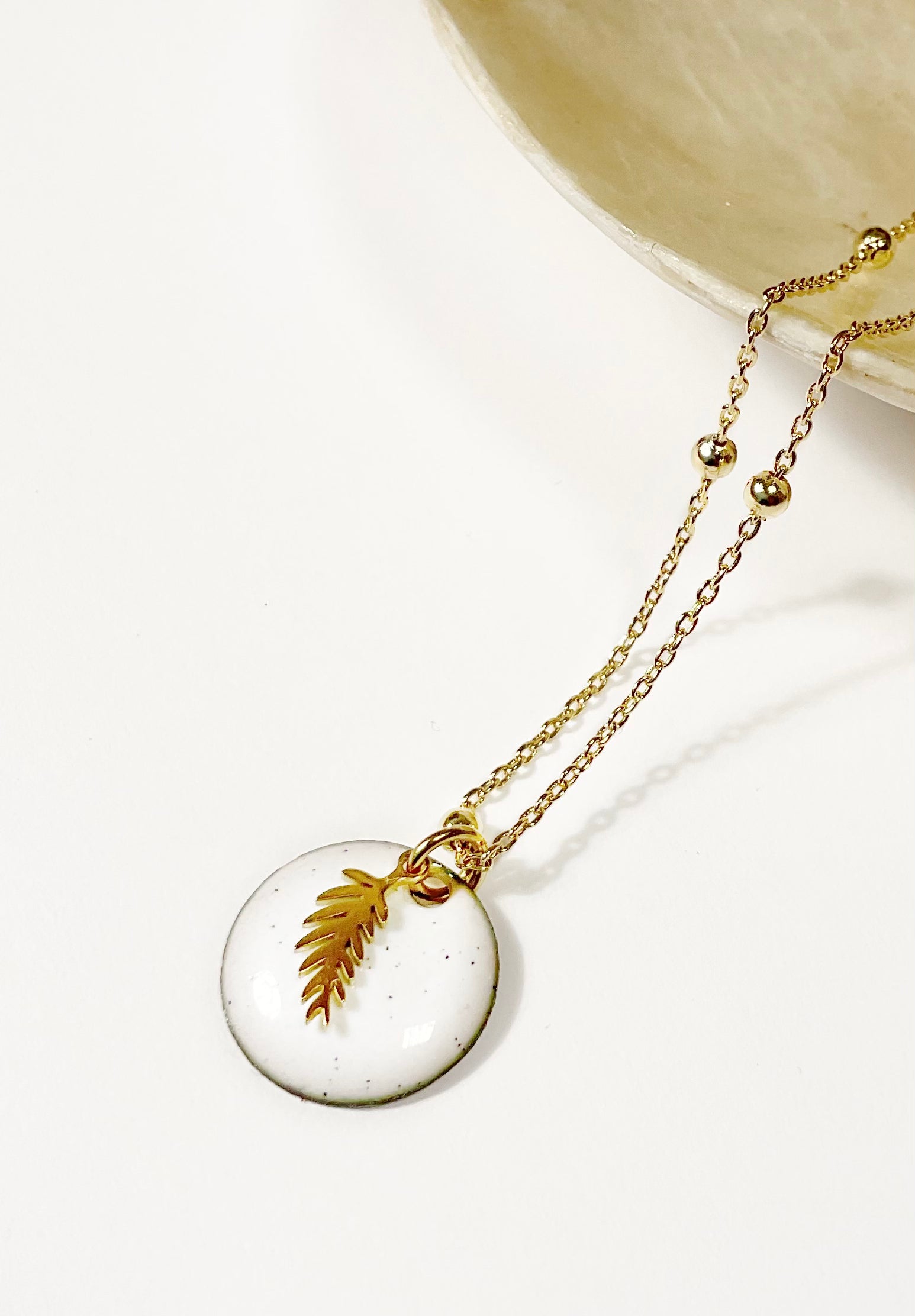 Collier Petite Médaille Ronde en Émail Blanc et Petite Feuille Dorée